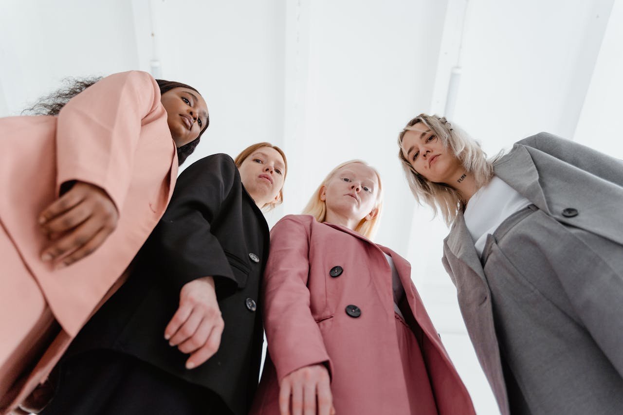 A diverse group of businesswomen in stylish suits, pictured from a low angle, exuding confidence.